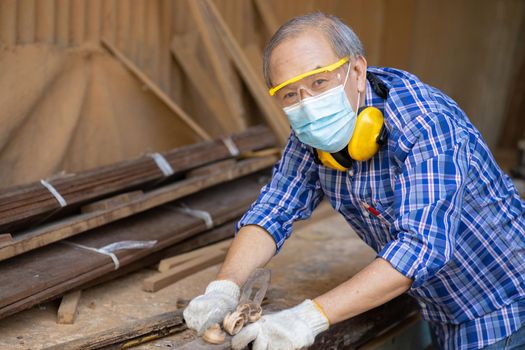 Portrait of elder wood worker hobby for good retirement, Asian male mature professional master of wood craft furniture wooden maker man.