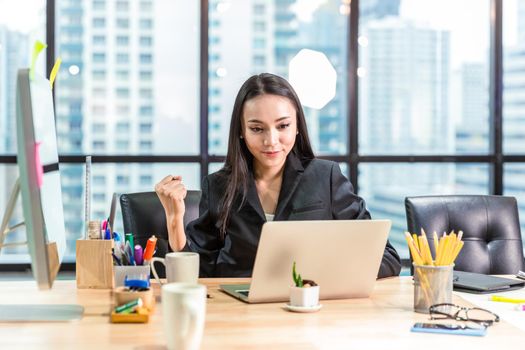 Happy success young Asian business women sitting at her desks in the office done or finish the job expression.