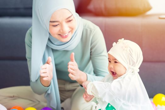 Muslim Mother happy smile enjoy playing with her baby  infant care happy together lovely home.