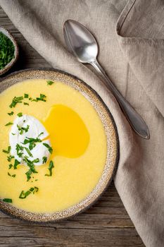 Polenta, porridge with Parmesan cheese and poached egg, vertical on old dark wooden background, top view. traditional Italian cuisine