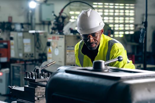Factory worker or engineer do machine job in adept manufacturing workshop . Industrial people and manufacturing labor concept .