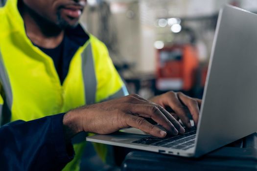 Factory worker working with laptop computer to do adept procedure checklist . Factory production line operator occupation quality control concept .