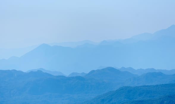 Blue mountain range silhouette with morning haze.
