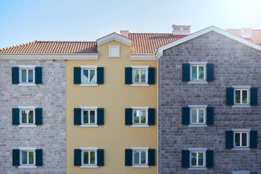 Facade of a new residential building with wall different finishing materials in Europe.