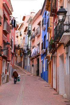 Villajoyosa, Alicante, Spain- April 22, 2022:Narrow cobbled street and beautiful colorful facades in Villajoyosa village, Alicante, Spain