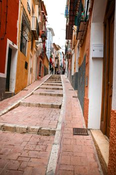 Villajoyosa, Alicante, Spain- April 22, 2022:Narrow cobbled street and beautiful colorful facades in Villajoyosa village, Alicante, Spain