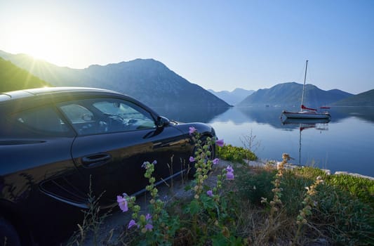 Sports car by the sea with mountain views, morning seascape with car.