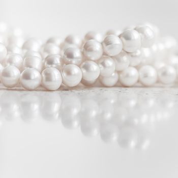 Nature white string of pearls on marble background in soft focus, with highlights