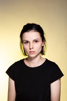 woman in black t-shirt on yellow background. High quality photo