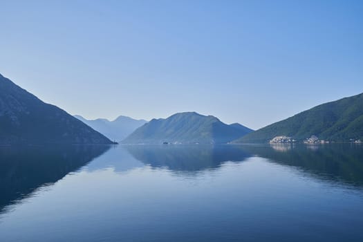 Morning seascape, reflection of mountains in sea water in Montenegro.