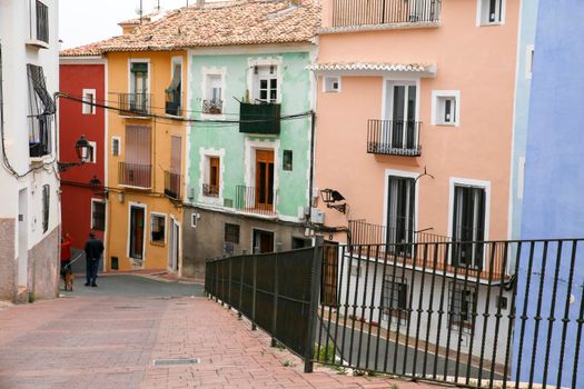 Villajoyosa, Alicante, Spain- April 22, 2022:Narrow cobbled street and beautiful colorful facades in Villajoyosa village, Alicante, Spain