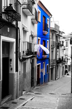 Villajoyosa, Alicante, Spain- April 22, 2022:Narrow cobbled street and beautiful colorful facades in Villajoyosa village, Alicante, Spain