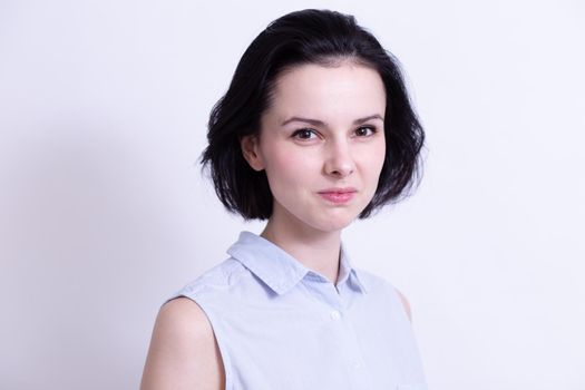 woman in a blue sleeveless office shirt, light background. High quality photo