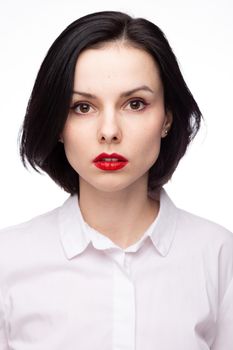 brunette woman with red lipstick on her lips in white shirt, white background. High quality photo
