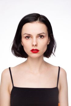 brunette woman with red lips in black top, white studio background. High quality photo