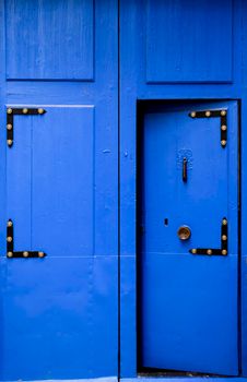 Blue wooden door with black metal knocker in Villajoyosa, Alicante, Spain.