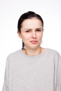 emotional woman in a gray sweatshirt, white background. High quality photo