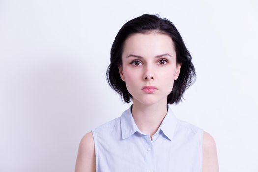 woman in a blue sleeveless office shirt, light background. High quality photo