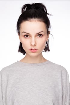 cute brunette woman with gray sweatshirt, white background. High quality photo