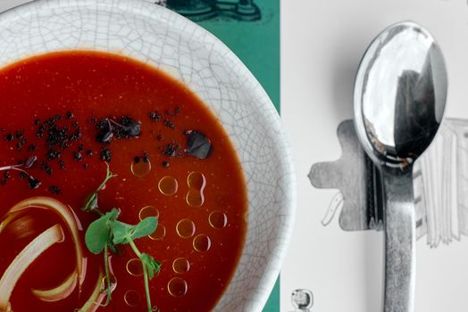 red soup, borscht, basil on the table with a spoon coarse. High quality photo