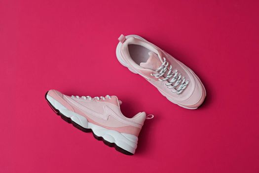 Unbranded modern sporty shoes, sneakers on a pink background. View from above.