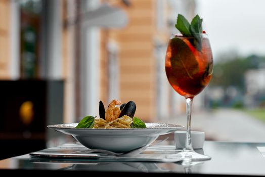 in the cafe a plate with mussels on the table with a glass of alcohol. High quality photo
