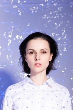 woman in a white shirt with blue polka dots, on a blue background. High quality photo