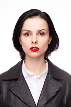 brunette woman with red lipstick on her lips in a black leather jacket and white shirt, white background. High quality photo