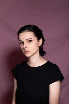 woman in black t-shirt on pink background. High quality photo