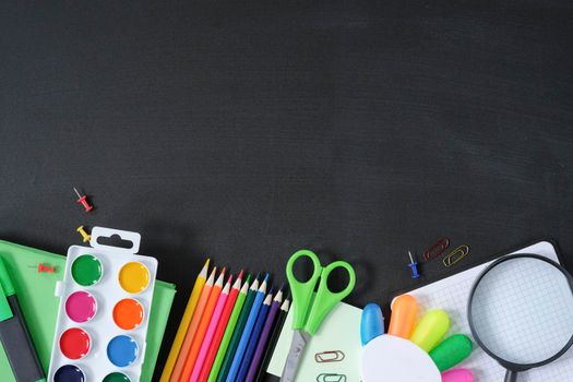 School supplies on black board background. Back to school concept