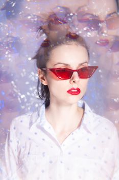 art portrait of a woman in glasses with red lipstick on her lips in a white shirt. High quality photo