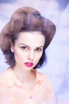 woman with pink lips in a hat on a blue background, art portrait. High quality photo