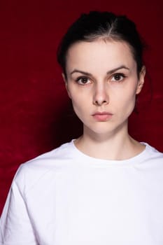 brunette woman in white t-shirt on red background. High quality photo