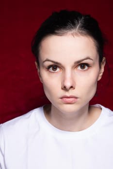 brunette woman in white t-shirt on red background. High quality photo