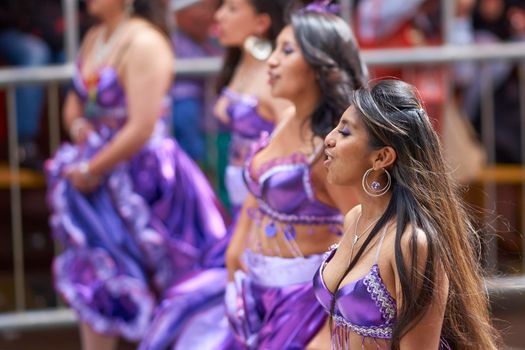 ORURO, BOLIVIA - FEBRUARY 25, 2017: Female dancers in colourful costumes parade through the mining city of Oruro on the Altiplano of Bolivia during the annual carnival.