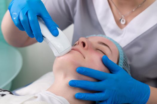 Young woman receiving electric galvanic anti-aging face spa massage at beauty salon. Galvanic massage helps to speed up metabolism, improve regeneration and restore skin protection from harmful external factors.