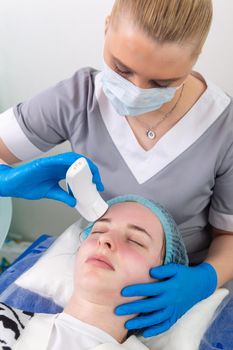 Young woman receiving electric galvanic anti-aging face spa massage at beauty salon. Galvanic massage helps to speed up metabolism, improve regeneration and restore skin protection from harmful external factors.