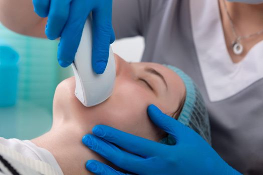 Young woman receiving electric galvanic anti-aging face spa massage at beauty salon. Galvanic massage helps to speed up metabolism, improve regeneration and restore skin protection from harmful external factors.