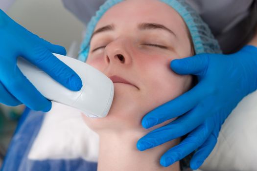 Young woman receiving electric galvanic anti-aging face spa massage at beauty salon. Galvanic massage helps to speed up metabolism, improve regeneration and restore skin protection from harmful external factors.