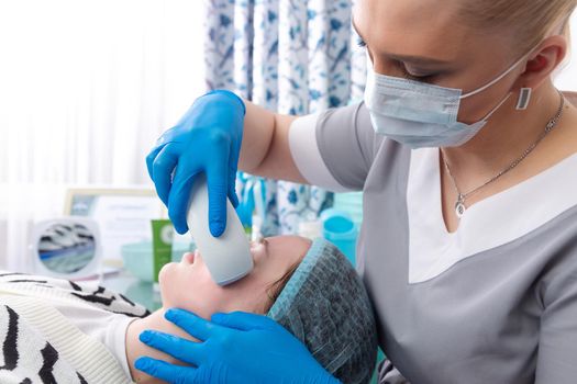 Young woman receiving electric galvanic anti-aging face spa massage at beauty salon. Galvanic massage helps to speed up metabolism, improve regeneration and restore skin protection from harmful external factors.