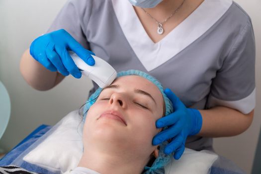 Young woman receiving electric galvanic anti-aging face spa massage at beauty salon. Galvanic massage helps to speed up metabolism, improve regeneration and restore skin protection from harmful external factors.