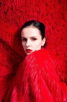 woman with red lips in red fluffy clothes, red fluffy background. High quality photo