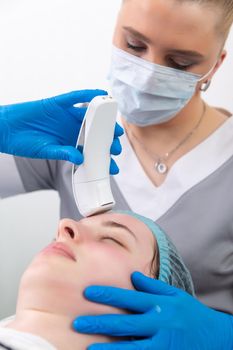 Young woman receiving electric galvanic anti-aging face spa massage at beauty salon. Galvanic massage helps to speed up metabolism, improve regeneration and restore skin protection from harmful external factors.