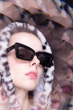 Art portrait, a woman in black glasses and a leopard hoodie. High quality photo