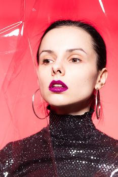 woman with purple lips in a black turtleneck with sequins on a red background. High quality photo