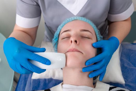 Young woman receiving electric galvanic anti-aging face spa massage at beauty salon. Galvanic massage helps to speed up metabolism, improve regeneration and restore skin protection from harmful external factors.