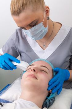 Young woman receiving electric galvanic anti-aging face spa massage at beauty salon. Galvanic massage helps to speed up metabolism, improve regeneration and restore skin protection from harmful external factors.