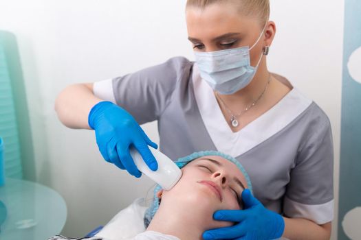 Young woman receiving electric galvanic anti-aging face spa massage at beauty salon. Galvanic massage helps to speed up metabolism, improve regeneration and restore skin protection from harmful external factors.