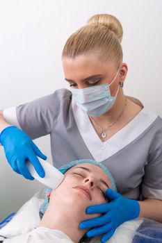 Young woman receiving electric galvanic anti-aging face spa massage at beauty salon. Galvanic massage helps to speed up metabolism, improve regeneration and restore skin protection from harmful external factors.