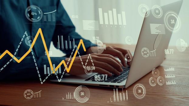 Businessman uses capable laptop computer to analyze business data analytic for marketing strategy and customer relationship management